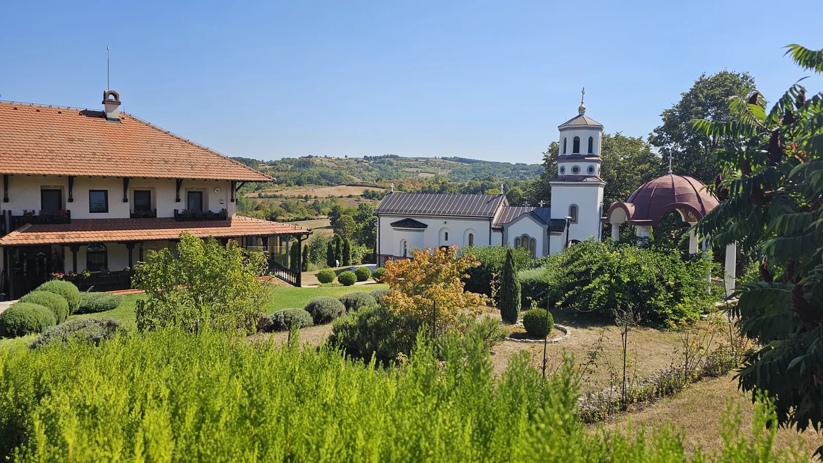 Porta manastira Lipar kod Kragujevca, sa crkvom, konakom i zelenilom među šumadijskim brdima