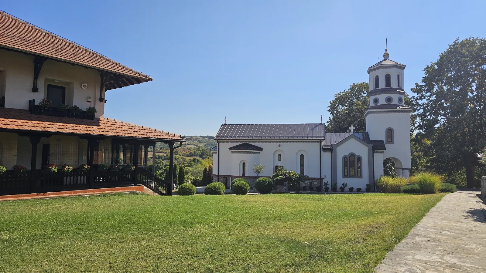 Crkva i konak manastira Lipar uz negovan travnjak i kamenu stazu